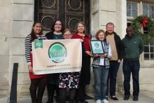 Staff holding winner plaque