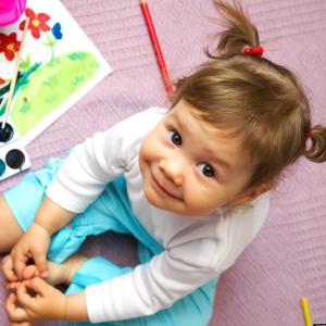 Child seated with watercolor paints